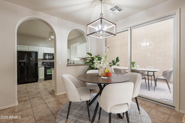 dining area featuring an inviting chandelier and light tile patterned floors