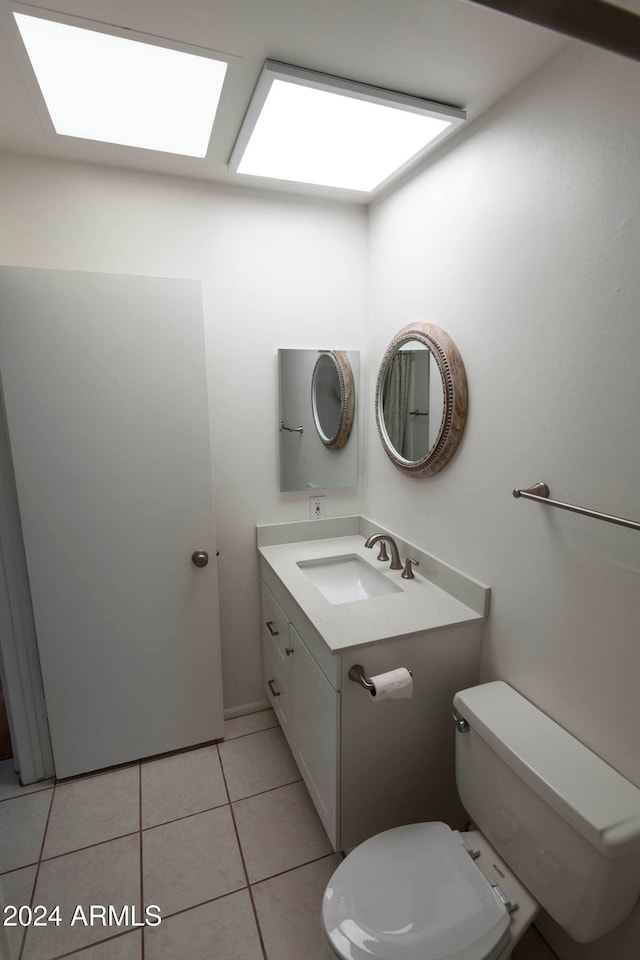 bathroom featuring tile patterned flooring, vanity, and toilet