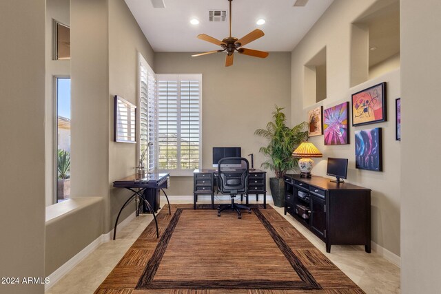 office featuring a towering ceiling and ceiling fan