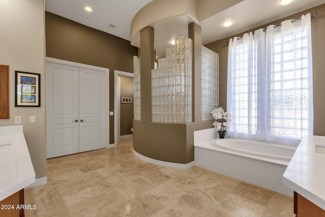 bathroom with vanity and a washtub