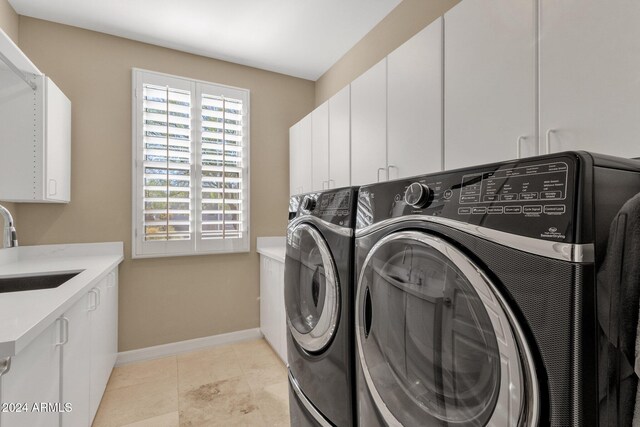 laundry area with cabinets, sink, and separate washer and dryer