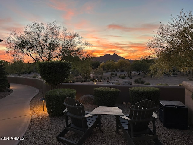 patio terrace at dusk featuring a mountain view