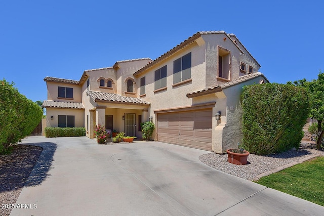 mediterranean / spanish-style home with a garage, stucco siding, and concrete driveway