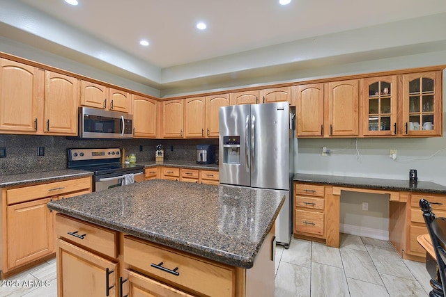 kitchen with a center island, dark stone countertops, stainless steel appliances, decorative backsplash, and glass insert cabinets