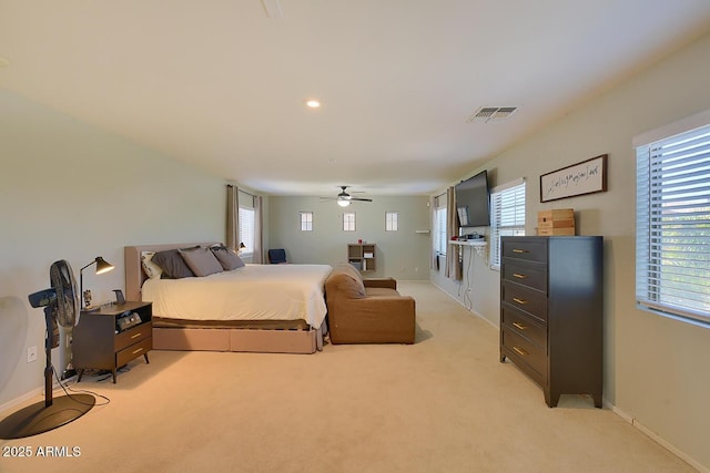bedroom featuring visible vents, a ceiling fan, baseboards, and light colored carpet