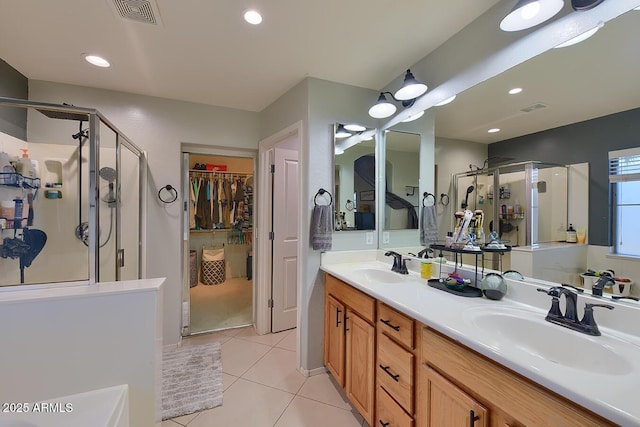 bathroom with a sink, a stall shower, and visible vents