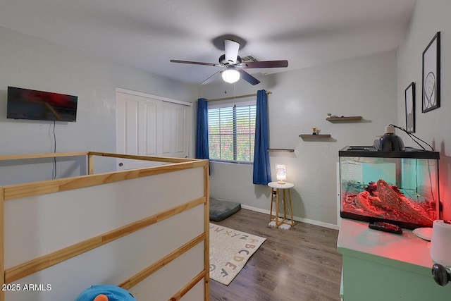 bedroom featuring baseboards, a ceiling fan, and wood finished floors