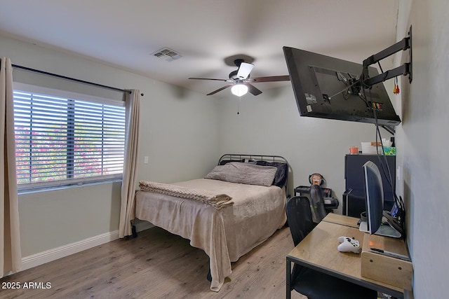 bedroom featuring a ceiling fan, baseboards, visible vents, and light wood-style floors