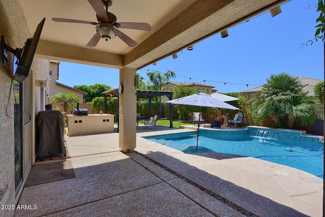 view of swimming pool featuring grilling area, a fenced in pool, a ceiling fan, a patio area, and exterior kitchen