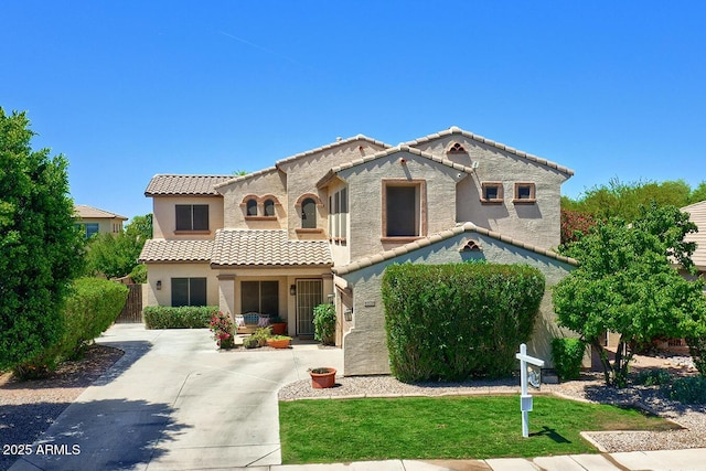 view of front of home featuring a front lawn, stucco siding, and a tile roof