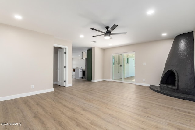 unfurnished living room featuring light hardwood / wood-style flooring, a fireplace, and ceiling fan