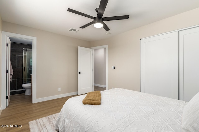 bedroom featuring light hardwood / wood-style flooring, ceiling fan, a closet, and ensuite bath