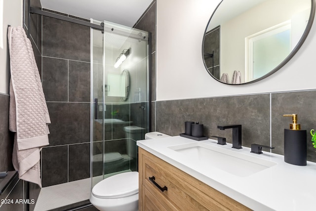 bathroom featuring toilet, walk in shower, vanity, and tile walls