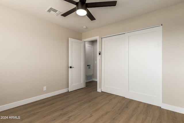 unfurnished bedroom featuring ceiling fan, a closet, and dark hardwood / wood-style flooring