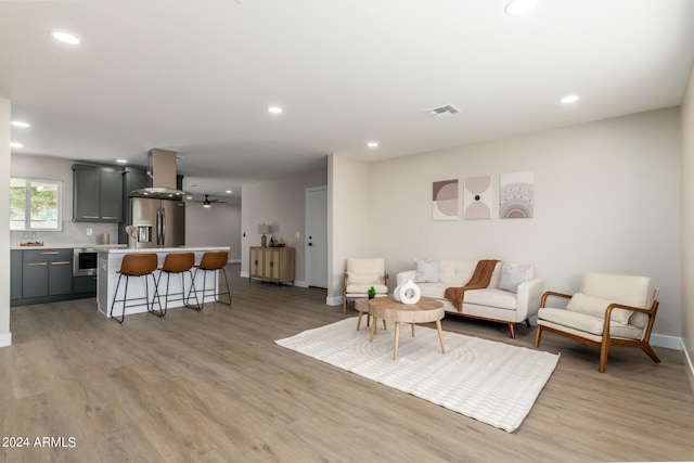 living room with light hardwood / wood-style floors and ceiling fan