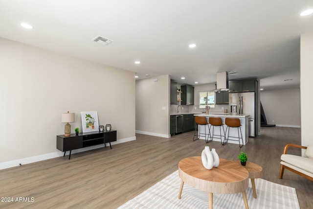 living room featuring hardwood / wood-style floors and sink