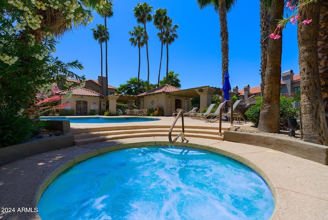 view of pool with a hot tub