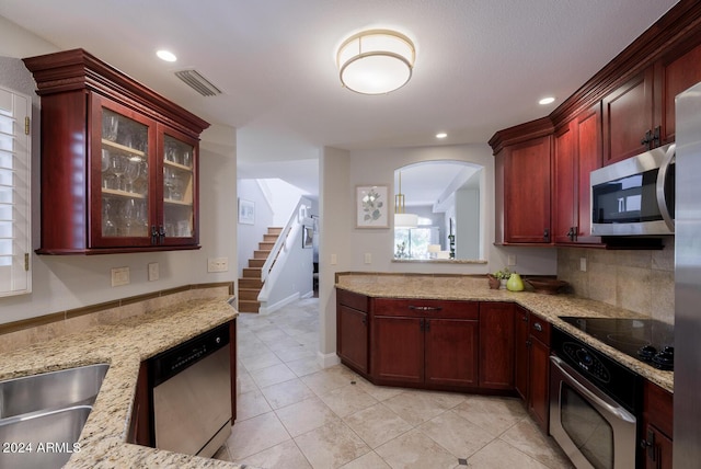 kitchen with sink, light stone countertops, tasteful backsplash, light tile patterned flooring, and stainless steel appliances