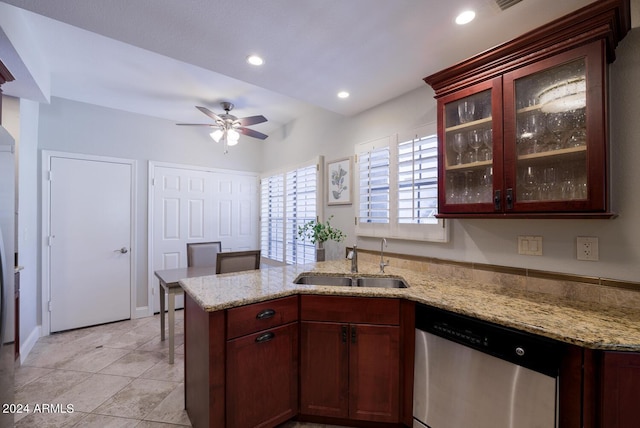 kitchen with stainless steel dishwasher, light stone counters, kitchen peninsula, and sink