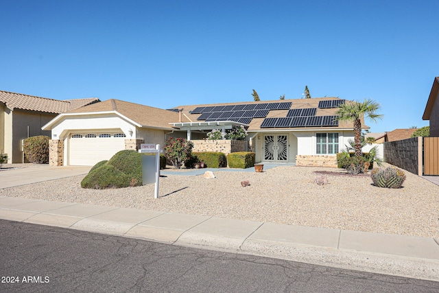 ranch-style home with a garage and solar panels