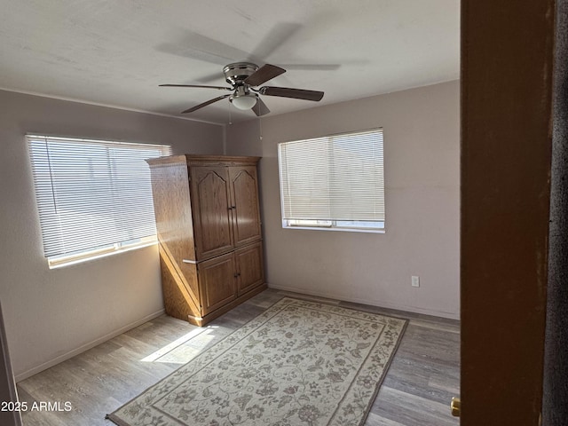 unfurnished bedroom featuring light wood-style floors, ceiling fan, and baseboards