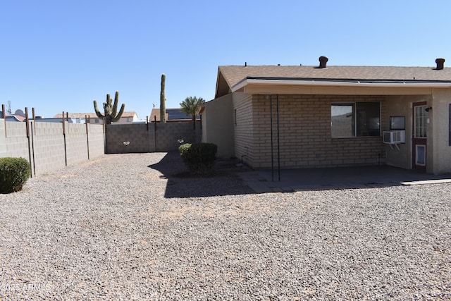 rear view of house featuring a patio area, a fenced backyard, and brick siding