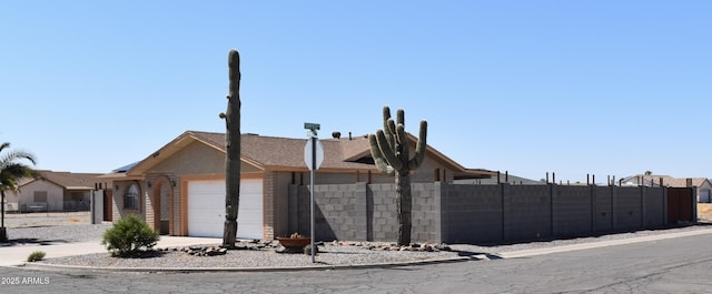 view of side of home featuring an attached garage and fence