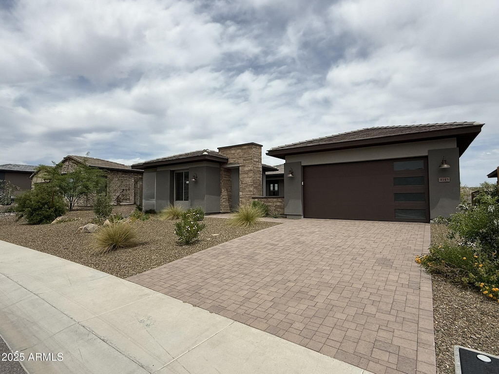 4145 Fence Post Way, Wickenburg, AZ 85390 - prairie-style home with stucco siding, decorative driveway, an attached garage, and stone siding
