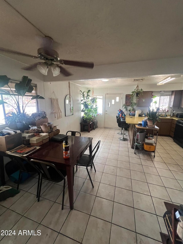 dining room featuring light tile patterned flooring, ceiling fan, and a textured ceiling