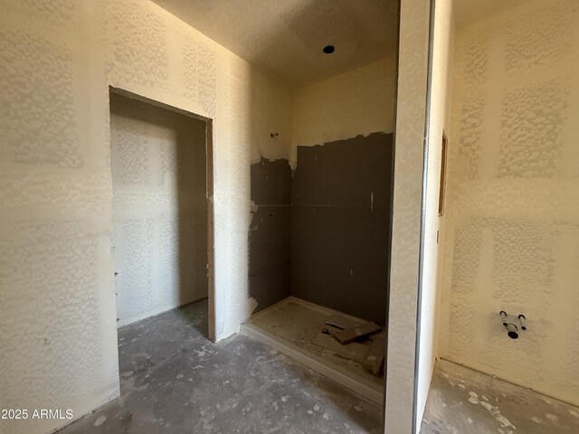 4517 S 95th Dr, Tolleson, AZ 85353 - bathroom with unfinished concrete floors, a shower stall, and a textured wall