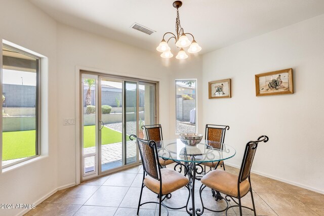 dining area featuring a chandelier and light tile patterned flooring