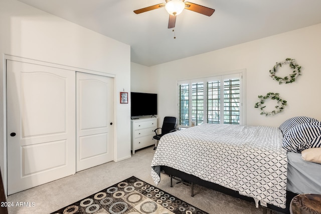 carpeted bedroom with ceiling fan and a closet