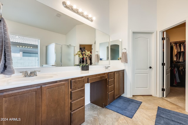 bathroom featuring lofted ceiling, vanity, a shower with shower door, and tile patterned floors