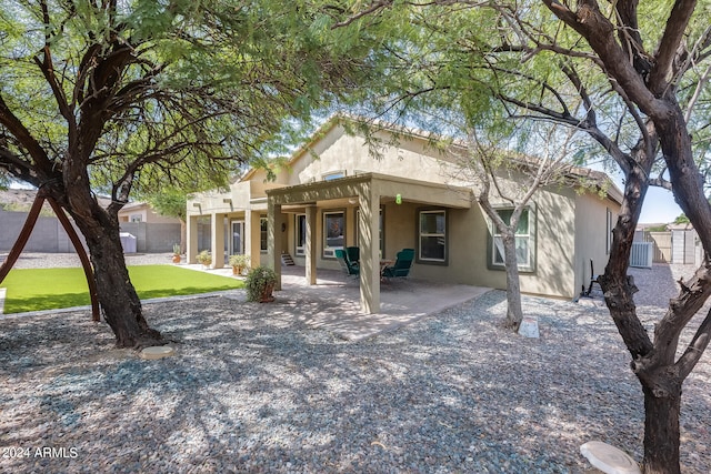 rear view of property featuring a lawn and a patio