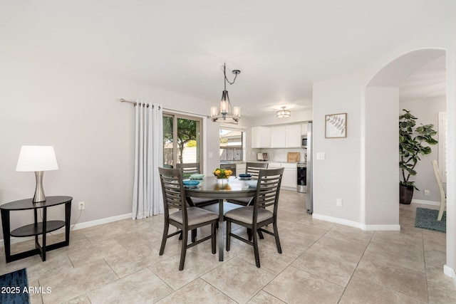 dining area with light tile patterned flooring and a notable chandelier