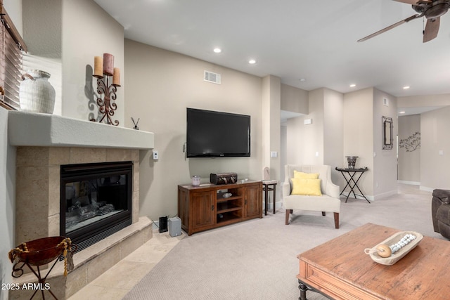 living room with light carpet, visible vents, a tile fireplace, ceiling fan, and recessed lighting