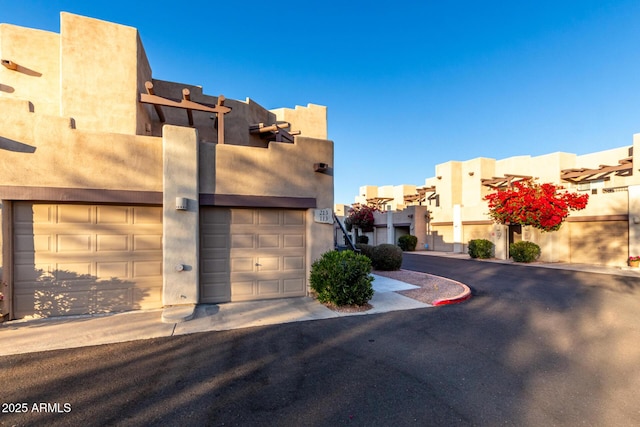 view of front facade with a garage, a residential view, and stucco siding