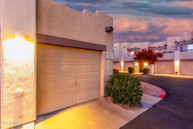 view of garage at dusk