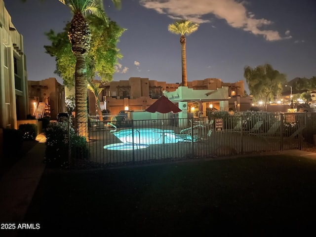 community pool with a patio area and fence