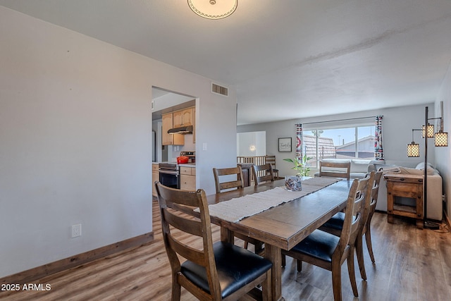 dining area featuring light wood finished floors and baseboards