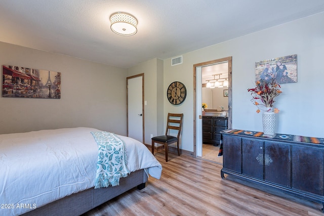 bedroom featuring wood finished floors and connected bathroom