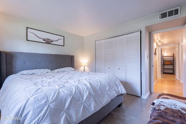 bedroom with finished concrete flooring, a closet, and baseboards