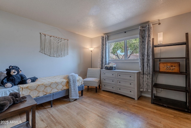 bedroom with light wood-style flooring and a textured ceiling