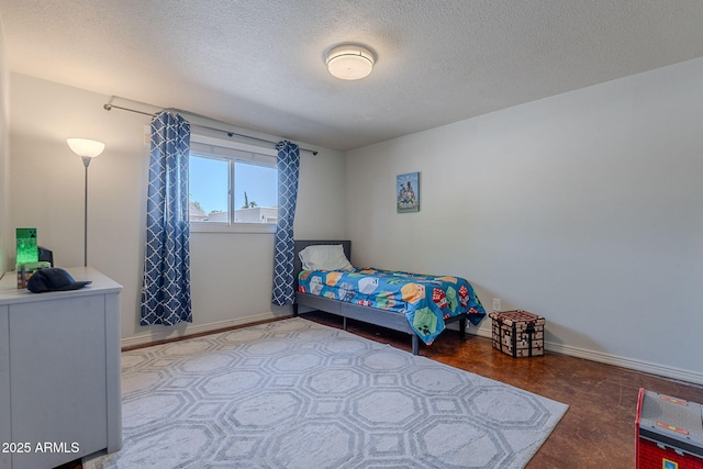 bedroom featuring a textured ceiling and baseboards