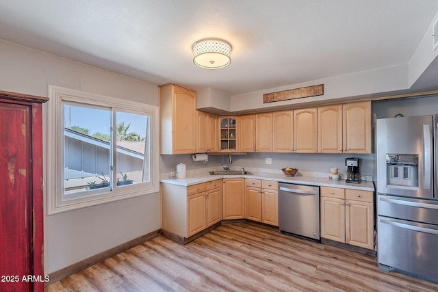 kitchen with appliances with stainless steel finishes, light brown cabinetry, light countertops, and light wood-type flooring
