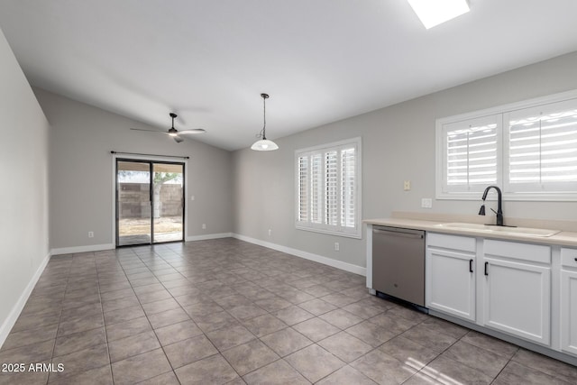 kitchen featuring a sink, stainless steel dishwasher, lofted ceiling, light tile patterned floors, and white cabinetry