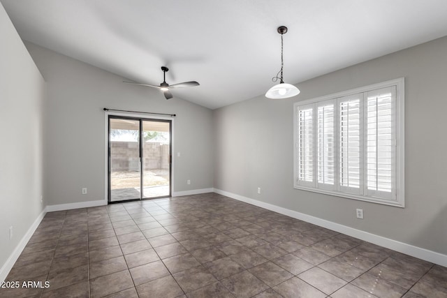 empty room featuring vaulted ceiling, a ceiling fan, dark tile patterned flooring, and baseboards