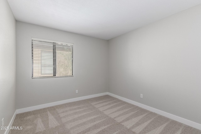 spare room with light carpet and baseboards