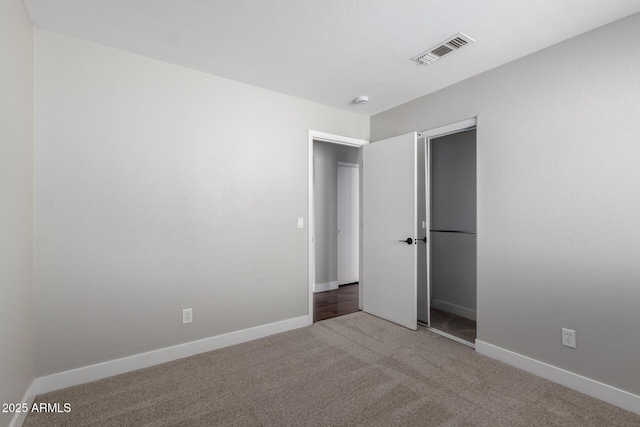 unfurnished bedroom featuring carpet flooring, baseboards, and a closet