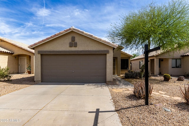 ranch-style home featuring an attached garage, concrete driveway, stucco siding, and a tile roof